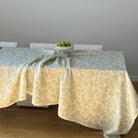 Sun lights up safari table with white linen featuring a delicate pistachio green design of subtle monkeys and floral patterns